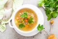 Summer light vegetarian vegetable soup with carrot, potato, cabbage and grean peas on white background. Diet healthy and tasty lun