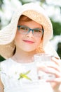 Summer little girl in straw hat drinking water outdoor portrait.