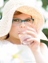 Summer little girl in straw hat drinking water outdoor portrait.