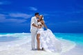 Summer love. Beautiful happy young couple in wedding clothes is standing on a beach in the Maldives. Engagements and wedding on Royalty Free Stock Photo