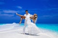 Summer love. Beautiful happy young couple in wedding clothes is standing on a beach in the Maldives. Engagements and wedding on Royalty Free Stock Photo