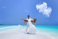 Summer love. Beautiful happy young couple in wedding clothes is standing on a beach in the Maldives. Engagements and wedding on Royalty Free Stock Photo