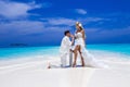 Summer love. Beautiful happy young couple in wedding clothes is standing on a beach in the Maldives. Engagements and wedding on Royalty Free Stock Photo