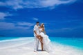 Summer love. Beautiful happy young couple in wedding clothes is standing on a beach in the Maldives. Engagements and wedding on Royalty Free Stock Photo