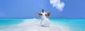 Summer love. Beautiful happy young couple in wedding clothes is standing on a beach in the Maldives. Engagements and wedding on Royalty Free Stock Photo