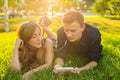 Summer, love and people concept - close up of happy teenage couple lying on grass with earphones and listening to music. Royalty Free Stock Photo