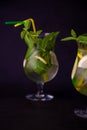 Summer mint lime refreshing cocktail mojito with rum and ice in glass on black background. Mojito cocktail on dark stone table. Royalty Free Stock Photo