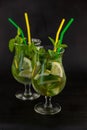 Summer mint lime refreshing cocktail mojito with rum and ice in glass on black background. Mojito cocktail on dark stone Royalty Free Stock Photo