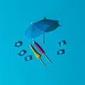 Summer mockup with blue pastel colors. many beach or cocktail umbrellas and ice cubes at midday sun and hard shadows at the Royalty Free Stock Photo