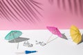 Summer mockup with white and pink pastel colors. many beach or cocktail umbrellas and ice cubes at midday sun and hard shadows Royalty Free Stock Photo