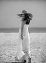 Summer model posing on the beach. Summer dress fashionable woman clothes. Young beautiful hipster woman with straw hat Royalty Free Stock Photo