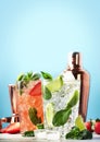 Summer Mojito cocktail or mocktail set with lime, mint, strawberry and ice in glass on blue background. Cold alcoholic or non- Royalty Free Stock Photo