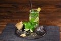 Summer mojito cocktail with rum, fresh lime, mint, crushed ice, ginger and carambola on a wooden background. Copy space. Royalty Free Stock Photo