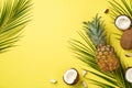 Summer mood concept. Top view photo of tropical fruits cracked coconuts pineapple and palm leaves on isolated yellow background Royalty Free Stock Photo