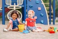 Caucasian and hispanic latin babies children sitting in sandbox playing Royalty Free Stock Photo