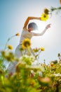 Summer mood. a young and cheerful girl posing against a background of blue sky and flowers. Happy girl among flowers and spring Royalty Free Stock Photo