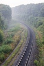 Summer morning landscape. Empty railroad turn in sunrise mist