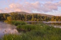 Summer morning on the river. Landscape with a river, a gentle blue morning sky, the first golden rays of the sun, lush Royalty Free Stock Photo