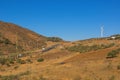 The highway, the groves of young olive trees, the wind power generator in sunny day. Spain, Andalusia