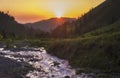 Summer mountain landscape at sunset with a stormy river on a slope with a spruce forest. Butakovo gorge in Almaty Kazakhstan Royalty Free Stock Photo