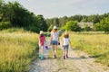 Summer, nature, children. Three girls walking with their backs on a country road Royalty Free Stock Photo