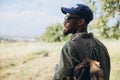 In summer in nature. Close-up young african man walking, strolling alone in forest, meadow, field. Amazing landscape Royalty Free Stock Photo