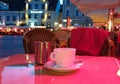 Summer night Street cafe bokeh blurring city light evening restaurant table cup of coffee on top view candle lamp light reflecti