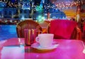 Summer night Street cafe bokeh blurring city light evening restaurant table cup of coffee on top view candle lamp light reflecti