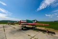 Old helicopter rotor plane on a green airfield.