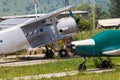 Old helicopter rotor plane on a green airfield.