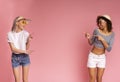 Summer offer. Joyful millennial girls in stylish wear pointing at copy space