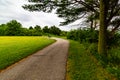 Summer in Omaha, Paved trail with a bench at a bend at Ed Zorinsky lake park, Omaha, Nebraska Royalty Free Stock Photo