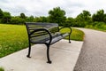 Summer in Omaha, Paved trail with a bench at a bend at Ed Zorinsky lake park, Omaha, Nebraska Royalty Free Stock Photo