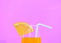 Summer orange juice with piece orange fruit in glass on pink background Royalty Free Stock Photo