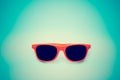 Summer orange sunglasses isolated in vignetting blue background. Minimal concept image for sun protection Royalty Free Stock Photo