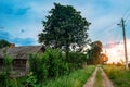 Summer orange sunset in a small Russian village. Rustic summer landscape. Grit effect. Wooden rural hut in the village