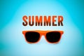 Summer orange text message and orange sunglasses isolated in vignetting blue background