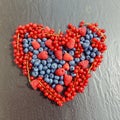 Summer organic berries on black table in heart shape. Agriculture, gardening and harvest concept.