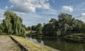 Summer outdoor park landscape heat warm weather green trees lake river blue sky clouds bright sun light recreation