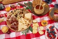 Summer outdoor picnic party. Food, honey and fruits lay on checkered blanket Royalty Free Stock Photo