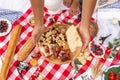 Summer outdoor picnic party. Food, honey and fruits lay on checkered blanket Royalty Free Stock Photo