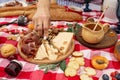 Summer outdoor picnic party. Food, honey and fruits lay on checkered blanket Royalty Free Stock Photo