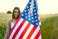 Summer outdoor portrait patriotic woman holding stars and stripes american flag