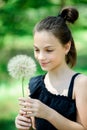 Summer outdoor portrait of a romantic girl with a big fluffy dandelion. the child holds a dry dandelion in his hands Royalty Free Stock Photo