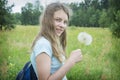 Summer outdoor portrait of a romantic girl with a big fluffy dandelion. the child holds a dry dandelion in his hands Royalty Free Stock Photo