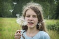 Summer outdoor portrait of a romantic girl with a big fluffy dandelion. the child holds a dry dandelion in his hands Royalty Free Stock Photo