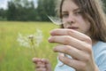 Summer outdoor portrait of a romantic girl with a big fluffy dandelion. the child holds a dry dandelion in his hands Royalty Free Stock Photo