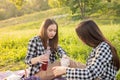 Summer outdoor recreation. Two millennial girls in the Park laughing, eating, chatting Royalty Free Stock Photo