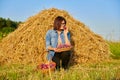 Summer rural woman portrait with basket of plums, dry hay sky background Royalty Free Stock Photo