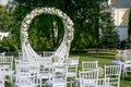 Summer outdoor wedding ceremony decoration. Beautiful white arch of branches and bouquet of white roses, hydrangeas and gypsophila Royalty Free Stock Photo